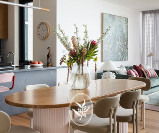 Modern kitchen and dining area with a vase of flowers on a table.